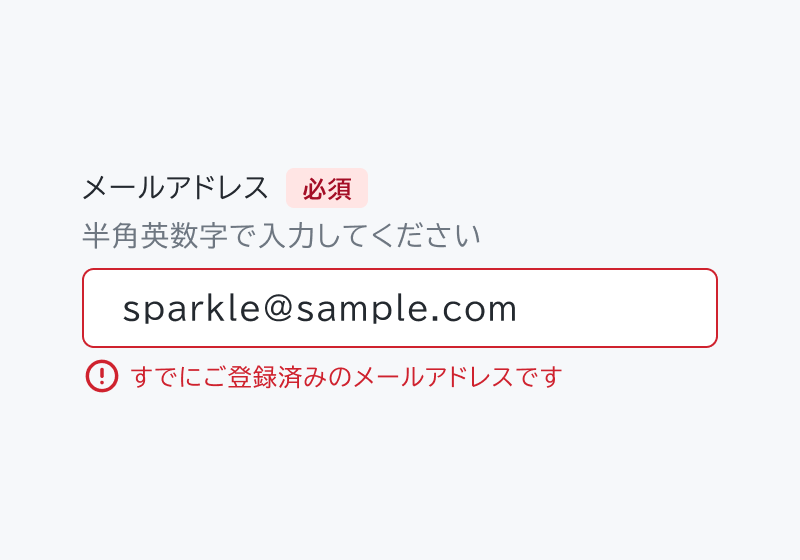 適切な使用例。「メールアドレス」と「必須」という赤いバッジ付きのヘッダー、「半角英数字で入力してください」というヘルパーテキスト、「sparkle@sample.com」という入力済みフィールド、「すでに登録済みのメールアドレスです」というエラーメッセージが表示されています。